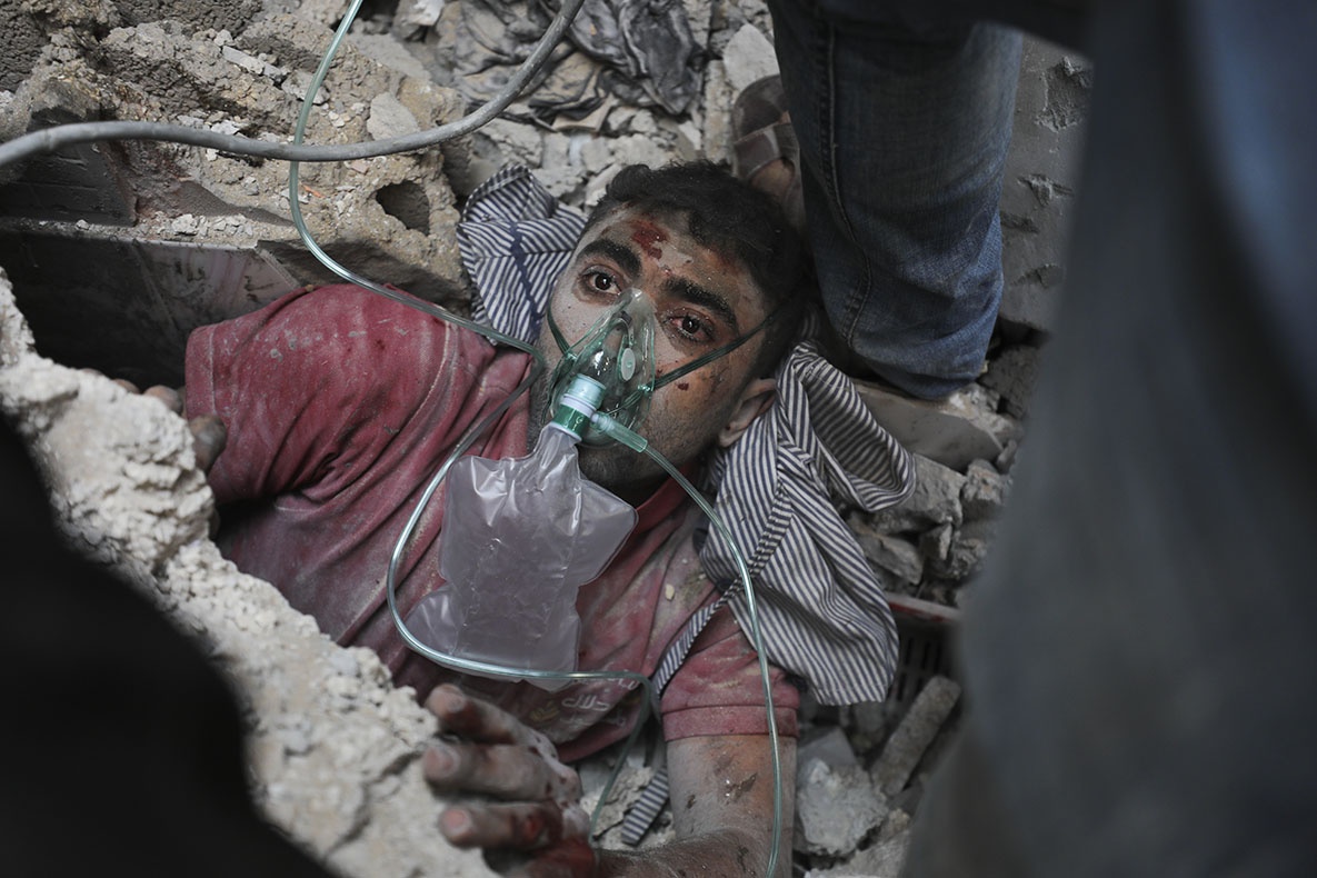 Palestinians rescue a survivor of Israeli bombardment of the Gaza Strip in Nusseirat refugee camp, October 24, 2023