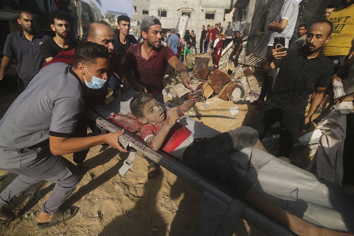 Palestinians pull a boy from the rubble after an Israeli strike on the Zaroub family house in Rafah, Gaza Strip, October 24, 2023