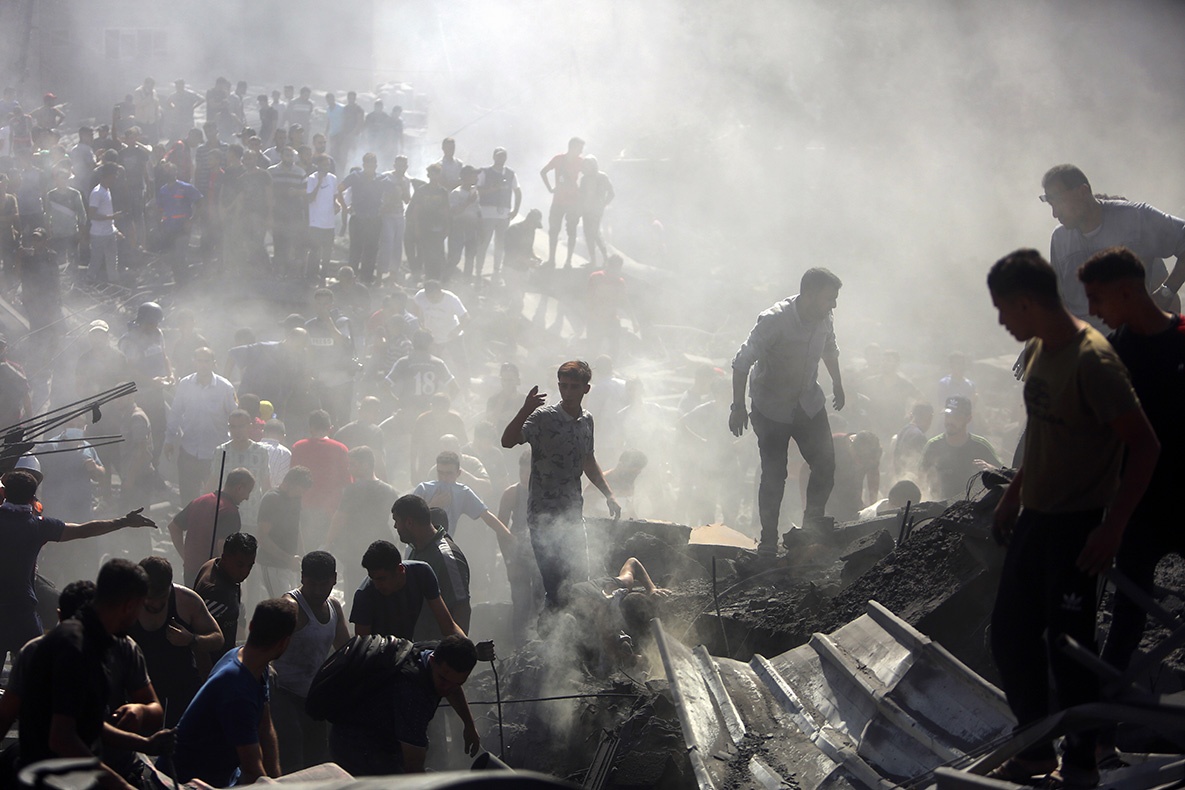 Palestinians inspect the rubble of destroyed buildings following Israeli airstrikes on the town of Khan Younis, southern Gaza Strip, October 26, 2023